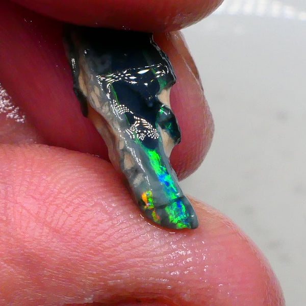 Green/Yellows/Blues on Black/Dark base seam opal rough 4.20cts Bright Bar thin visible all around 19x7x6mm Lot B4-A477